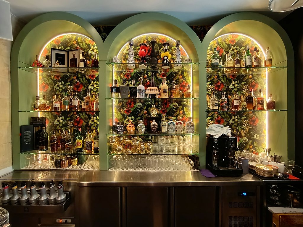 Bar with arched display niches and floral arrangements