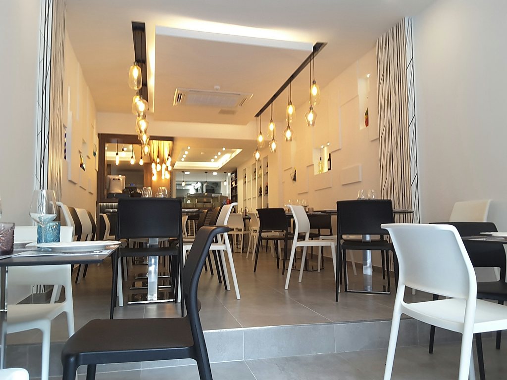 Restaurant dining room lit by a run of filament pendants