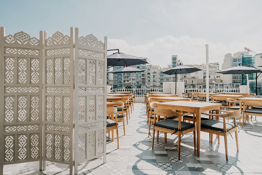 Roof terrace laid for service behind carved screens, over the rooftops