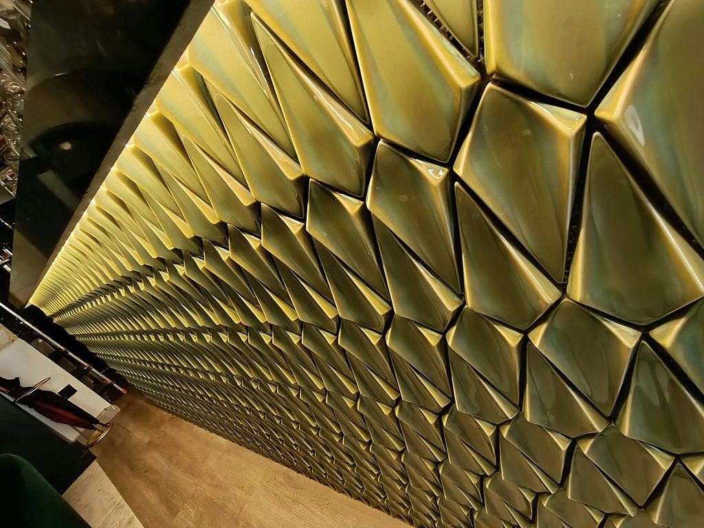 Faceted gold wall panel, detail of a hospitality fit-out